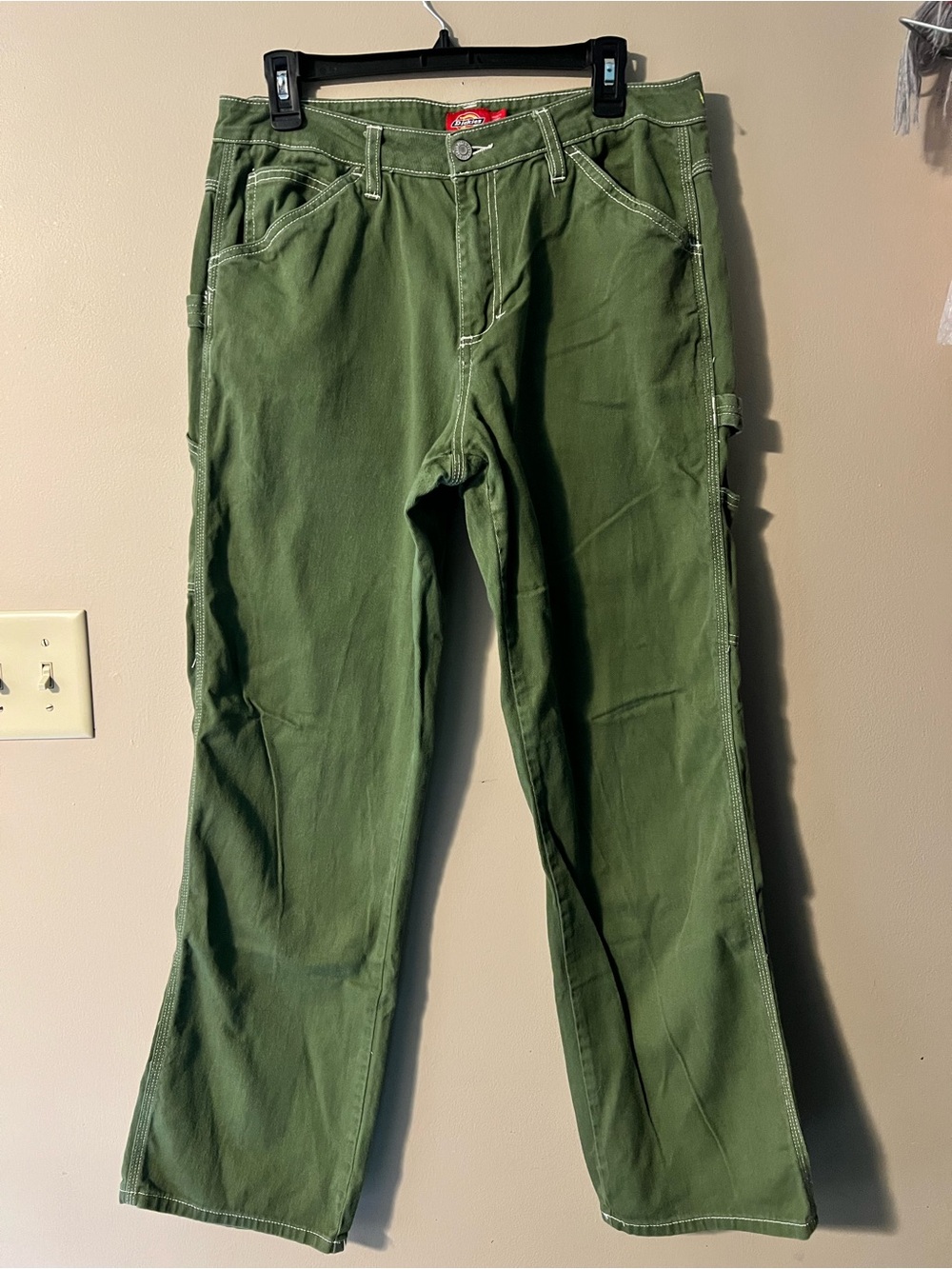 Dickies red label green carpenter pants with white contrasting stitching.